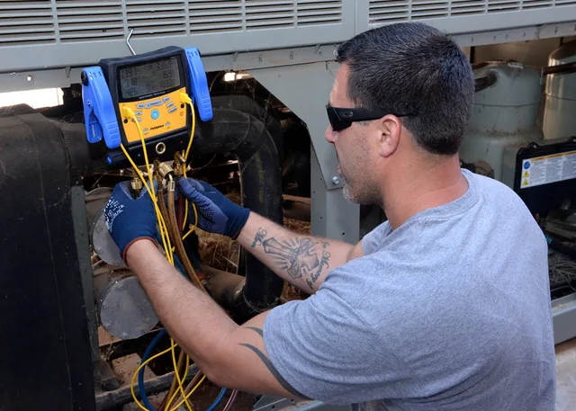 Matt McKee, 97th Civil Engineer Squadron heating, ventilation and air conditioning technician, uses a digital gauge to check the status of a chiller located at Building 228, Aug. 5. The Altus AFB HVAC shop is responsible for regulating the temperature throughout all base facilities, maintaining work. HVAC Contractor Compliance Checklist: Organize Records